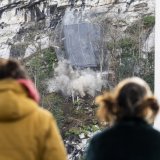 Des curieux regardent des blocs de pierre tomber de la paroi surplombant le quartier de la Barme à Collombey-Muraz (VS).