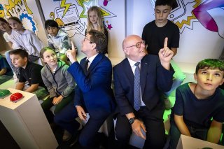 Le conseiller fédéral Albert Rösti et le directeur général des CFF Vincent Ducrot (au centre de la photo) ont inauguré le nouveau wagon thématique, entourés d'enfants. KEYSTONE/MICHAEL BUHOLZER