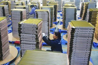 Des ouvriers travaillent dans une usine de radiateurs de refroidissement pour climatiseurs dans la province d'Anhui en Chine centrale. KEYSTONE/AP CHINATOPIX