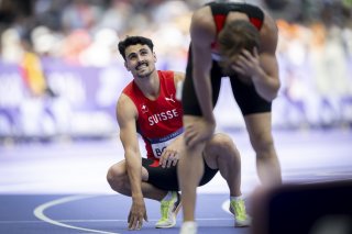 Julien Bonvin, left, and Berke Akcam of Turkey, right, react after crossing the finish line, during the men's 400m hurdles repechage Round at the 2024 Paris Summer Olympics in Paris, France, Tuesday, August 6, 2024. (KEYSTONE/Anthony Anex)