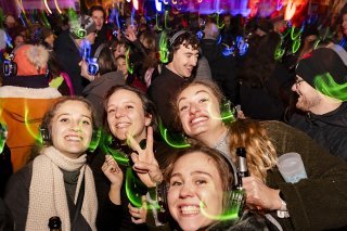 Des personnes fêtent le passage de la nouvelle année lors de la Silent Disco organisée à Lausanne. KEYSTONE/Jean-Christophe Bott