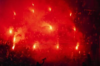 Les supporters genevois ont allumé samedi des fumigènes lors de la rencontre de Super League entre FC Lausanne-Sport et Servette FC au stade de la Tuilière à Lausanne. KEYSTONE/JEAN-CHRISTOPHE BOTT