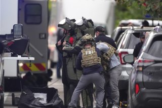Des représentants des forces de l'ordre en tenue de protection pour enquêter après un attentat à Boulder, dans le Colorado dimanche. KEYSTONE/AP/David Zalubowski