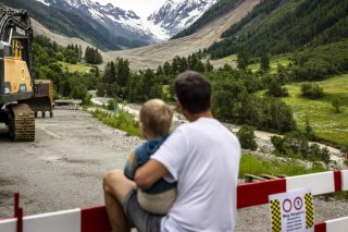 Les habitants du Lötschental scrutent la rivière Lonza. KEYSTONE/MICHAEL BUHOLZER