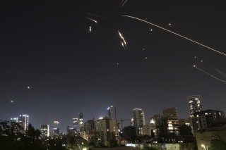 Le système de défense aérienne israélien intercepte vendredi soir des missiles lancés depuis l'Iran à Ramat Gan, près de Tel Aviv. KEYSTONE/AP/Oded Balilty