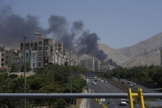 De la fumée s'élève d'un dépôt pétrolier touché par une frappe israélienne samedi, à Téhéran. KEYSTONE/AP/Vahid Salemi