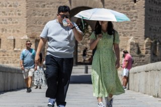 Des touristes se protègent du soleil lors d'une visite à Valence, en Espagne. KEYSTONE/EPA/MANUEL BRUQUE
