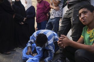 Mohammed Abu Qas pleure sur le corps de sa soeur de 12 ans tuée par un bombardement israélien, à l'hôpital de Nuseirat. KEYSTONE/AP/Abdel Kareem Hana