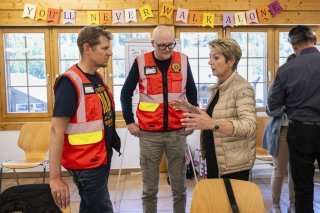 Deux membres de l’État-major de conduite régional du Lötschental avec la présidente de la Confédération Karin Keller-Sutter.