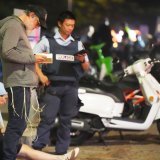 Des passants restent sur place tandis que la police établit un périmètre de sécurité à Bondi Beach après une fusillade signalée à Sydney, dimanche. KEYSTONE/AP/Mark Baker