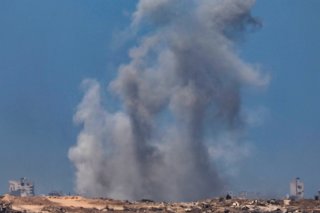 De la fumée s'élève à la suite d'une frappe aérienne israélienne dans la banlieue de Gaza, vue depuis le côté israélien de la frontière avec Gaza, dans le sud d'Israël, lundi. KEYSTONE/EPA/ATEF SAFADI