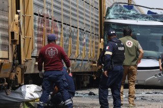 Les secouristes évacuent un corps sur le lieu de l'accident entre un bus à impériale et un train, sur un passage à niveau. KEYSTONE/AP/Ramses Mercado Valdes