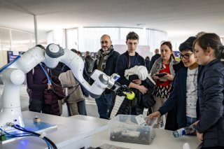 Des personnes regardent un robot qui reproduit l'agilité humaine lors de la journée de l'intelligence artificielle, IA, le samedi 23 novembre 2024 à l'EPFL. (Photo d'illustration) KEYSTONE/JEAN-CHRISTOPHE BOTT