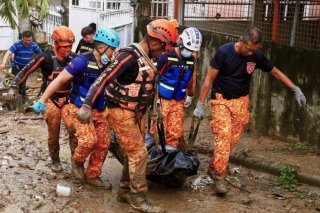 Des sauveteurs transportent un corps après la passage du typhon Kalmaegi à Cebu city. KEYSTONE/AP/Jacqueline Hernandez