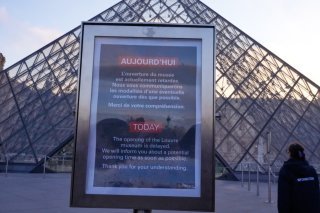 Un panneau indiquait lundi matin aux touristes que l'ouverture du musée du Louvre à Paris était "retardée". KEYSTONE/AP/Michel Euler