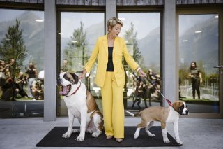 Karin Keller-Sutter pose avec les chiens Zeus, dont elle est marraine, et Xcel.