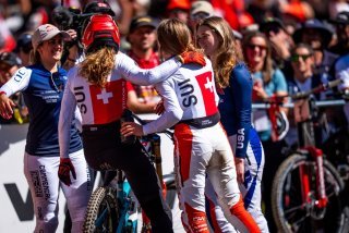 Camille Balanche (à gauche) et Lisa Baumann (à droite) se font une accolade dans l'aire d'arrivée au terme de la descente des Mondiaux de VTT