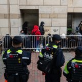 Quelque 70 personnes ont fait la queue jeudi matin pour entrer au tribunal de première instance de West Kowloon, où des dizaines de policiers étaient déployés. KEYSTONE/AP/Chan Long Hei