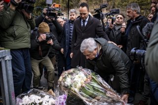 Accompagné de Mathias Reynard, le chef de la diplomatie italienne Antonio Tajani a déposé une gerbe devant le bar "Le Constellation". KEYSTONE/EPA/JEAN-CHRISTOPHE BOTT