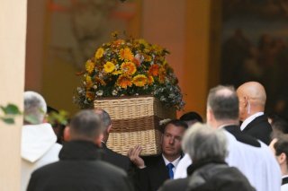 Le cercueil de Brigitte Bardot recouvert de simple rotin est porté à l'issue de la cérémonie pour sa dernière demeure au cimetière marin. KEYSTONE/AP/Philippe Magoni