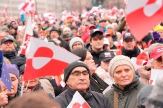 Sous un ciel gris et brumeux, les manifestants, munis de drapeaux groenlandais et danois, formaient une marée rouge et blanche aux couleurs de ces drapeaux. KEYSTONE/AP/Emil Helms