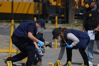 Des enquêteurs médico-légaux placent des marqueurs de preuves sur les lieux où les deux policiers ont été tués lors d’attaques survenues dans une prison abritant des chefs de gangs, à Villanueva, en périphérie de Guatemala City. KEYSTONE/AP/Moises Castillo