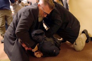 L'individu qui a projeté un liquide sur Ilhan Omar a été plaqué au sol par le service de sécurité. KEYSTONE/AP/Richard Tsong-Taatarii