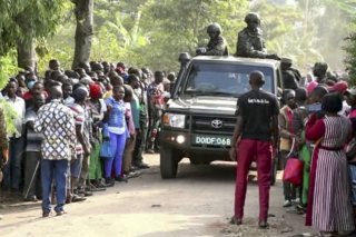Les forces de sécurité ougandaises tentent de maintenir le calme au milieu de mla foule après l'attaque.