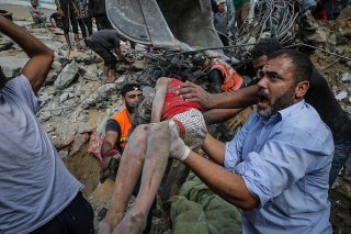 Des Palestiniens récupèrent le corps d'une fillette dans les ruines de sa maison familiale dans le camp de réfugiés d'Al Shatea, à Gaza. KEYSTONE/EPA/MOHAMMED SABER