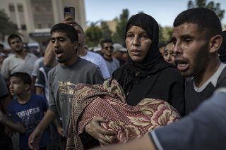 Une femme porte le corps de son enfant tués dans un bombardement israélien sur le camp de réfugiés de Khan Younes, dans le sud de la bande de Gaza. KEYSTONE/EPA/HAITHAM IMAD