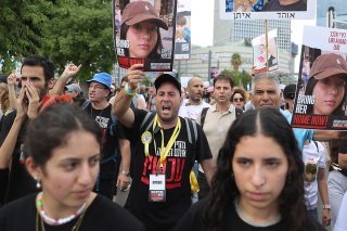 Une centaine de proches d'otages et leurs soutiens sont partis à pied mardi de la place du musée des beaux-arts de Tel-Aviv, portant des t-shirts noirs et brandissant des portraits d'otages. Ils sont en route pour Jérusalem. KEYSTONE/EPA/ABIR SULTAN