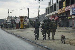 Des soldats israéliens patrouillent dans une ville palestinienne, complètement vidée après que l'armée israélienne ait fermé les commerces et banni les véhicules palestiniens de la route principale. KEYSTONE/AP/Mahmoud Illean