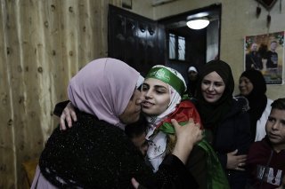 Une prisonnière palestinienne libérée, Aseel al-Titi, portant un bandeau du Hamas, est accueillie par ses proches et ses amis à Balata, camp de réfugiés palestiniens à Naplouse, en Cisjordanie occupée. KEYSTONE/AP/Majdi Mohammed