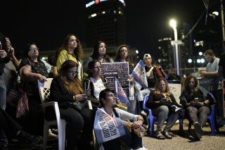 Des Israéliens scrutent un écran géant dans l'attente de la libération d'un second groupe d'otages samedi. Le Hamas a toutefois reporté l'échange otages-prisonniers. KEYSTONE/AP/Leo Correa