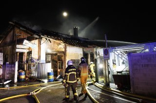 Les pompiers du Service d'incendie et de secours (SIS) interviennent sur le feu d'un garage, à Vernier près de Genève. Le sinistre a causé d'importantes perturbations routières et ferroviaires. Le trafic aérien a été touché pendant quelques minutes. (KEYSTONE/Salvatore Di Nolfi) KEYSTONE/SALVATORE DI NOLFI