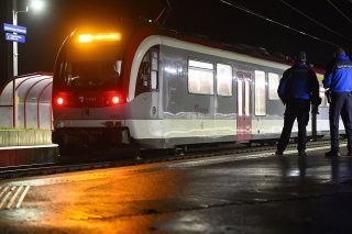 Des policiers postés en fin de soirée jeudi devant le train régional visé par une prise d'otages, quelques heures auparavant, à la gare d'Essert-sous-Champvent (VD). KEYSTONE/LAURENT GILLIERON