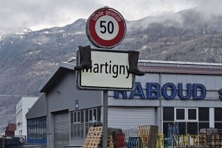 Des bottes suspendues au panneau de signalisation à l'entrée de Martigny comme dans d'autres localités : une façon pacifique de sensibiliser aux conditions de l'agriculture